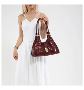 Vue détaillée du sac à bandoulière en cuir verni bordeaux avec boucle carrée dorée
