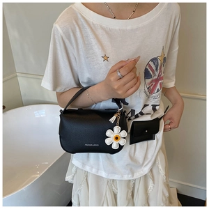 Detail of black litchi pattern bag with floral charm and detachable small pouch