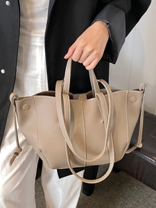 Minimalist beige pebble leather tote bag with drawstrings and adjustable shoulder strap