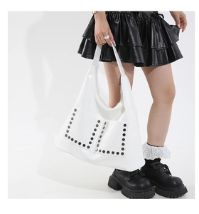Detail of white tote bag with silver hexagonal rivets and double front pocket design
