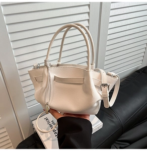 Detail of white lychee pattern leather bucket bag with silver hardware and dual handles