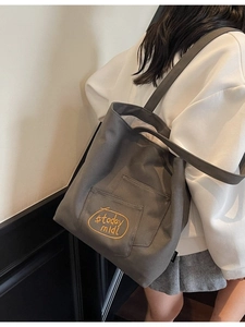 Minimalist grey canvas tote bag for women with exterior pocket and yellow embroidery