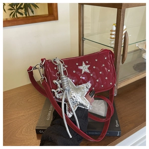 Detail of red patent leather quilted crossbody bag with star stud and balloon dog charm
