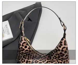 Detail of retro leopard print shoulder bag with gold zipper and adjustable buckle