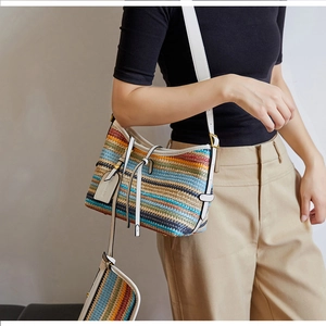 Close-up of colorful woven crossbody bag with striped pattern and white leather details