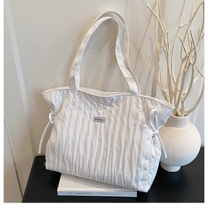 Vista dettagliata della borsa tote bianca trapuntata con texture arricciata e coulisse