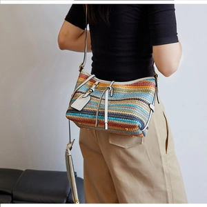 Detail of colorful woven straw bag with white leather straps and golden hardware accents