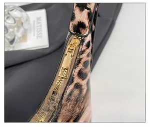 Detail view of high-quality smooth golden metal zipper on vintage leopard print handbag