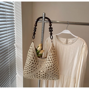 Detail of hand-woven beige tote with diamond crochet patterns and wooden bead handles