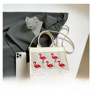 Détail du sac en cuir crème et tissu avec broderie élégante de flamants rouges