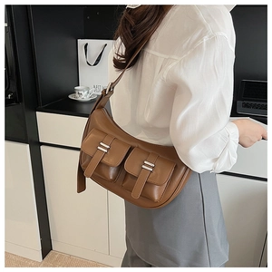 Detailed close-up of brown vintage matte leather bag with dual silver buckle pockets