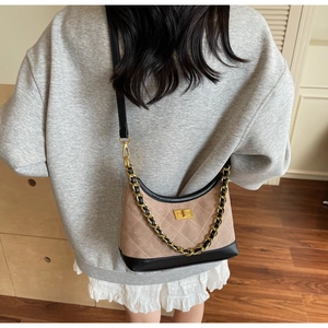 Détail de la texture en daim matelassé et du fermoir doré du sac hobo porté croisé