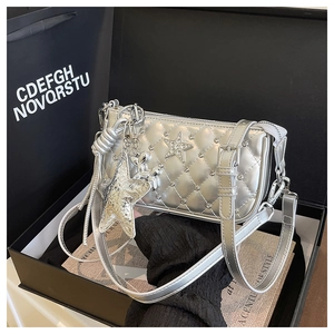 Detail of silver metallic quilted crossbody bag with star rhinestones in a gift box