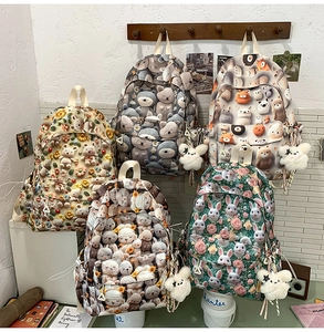 Detail of five cute canvas backpacks with various animal patterns and star plush pendants