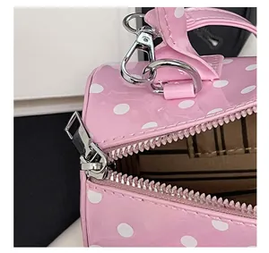 Détail du sac à main rose à pois montrant la fermeture éclair et la doublure rayée