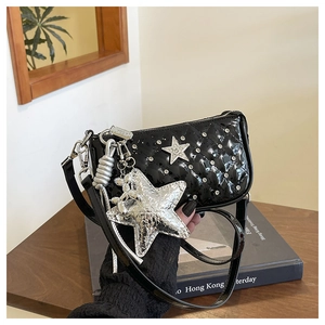 Detail of glossy black quilted shoulder bag with rhinestone star and silver pendant