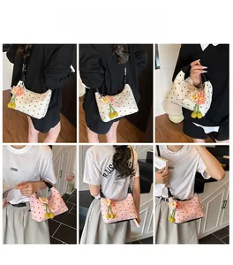 Gesteppte Baguette-Taschen in Beige und Rosa mit Blumenanhängern und Schmetterlingsmuster
