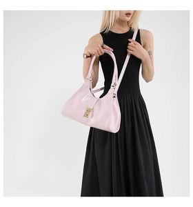 Gros plan d'un sac à main en cuir verni rose clair avec boucle en métal doré