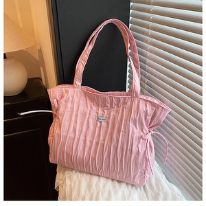 Dettaglio della borsa tote rosa a pieghe con design a coulisse ed etichetta