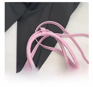 Détail du sac cylindrique rose à pois avec chaîne de perles et anneaux métalliques