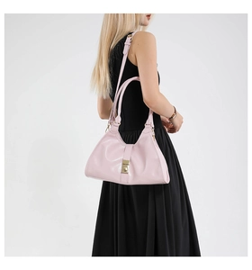 Détail du sac sous l'aisselle en cuir verni rose brillant avec boucle en métal