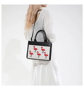 Détail du cabas tissé avec motifs flamants roses et bandoulière en cuir noir