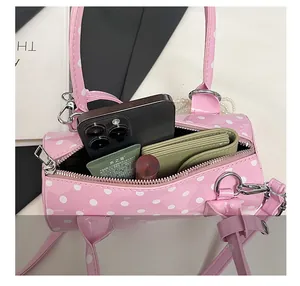Vue intérieure du sac cylindrique rose à pois montrant l'espace pour le téléphone