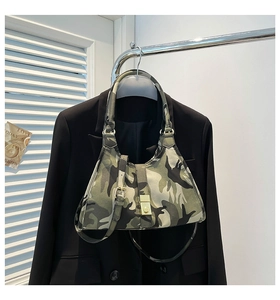 Détail du sac sous le bras camouflage avec une texture de toile et une boucle en métal doré