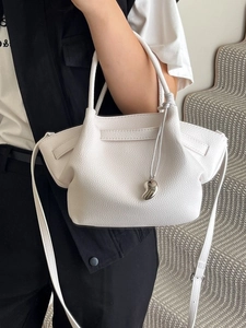 Minimalist white lychee leather bucket bag with silver heart charm and shoulder strap
