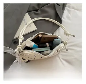Internal view of a polka dot baguette bag showing storage for phone and cosmetics