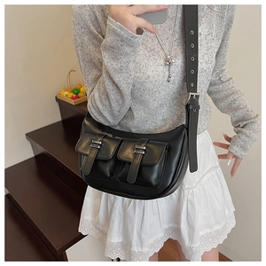 Detail of black leather biker-style underarm bag with double utility pockets and silver buckles
