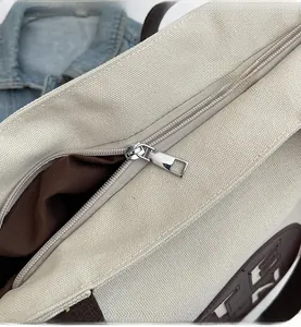 Detailed close-up showing the smooth silver zipper and interior lining of the canvas tote bag