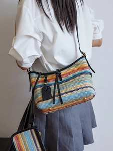 Fashionable woven straw shoulder bag with colorful stripes and black leather trim accents