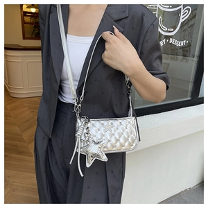 Detail view of silver quilted crossbody bag featuring star rhinestones and charms