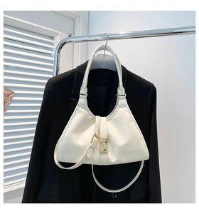 Détail du sac à main crème avec boucle en métal doré et finition en cuir verni brillant