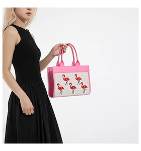 Détail du sac cabas rose avec broderies de flamants rouges et anses en cuir