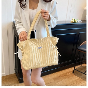 Dettaglio borsa shopper giallo zenzero con trama a pieghe e coulisse laterali alla moda