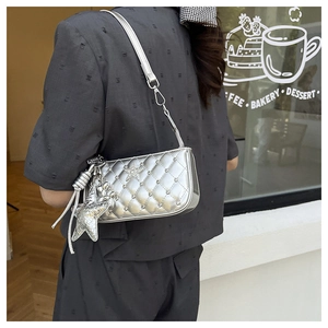 Detail of silver quilted crossbody bag with diamond studs and star pendant for women