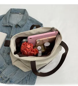 Spacious interior of canvas tote bag showing storage for tablet and cosmetics