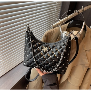 Détail du sac hobo matelassé noir avec étoile argentée et cuir verni brillant