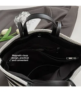Gros plan sur le fermoir magnétique et les compartiments de ce grand sac cabas rayé