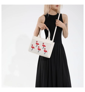 Sac carré chic en toile crème avec broderie flamant rouge porté par un mannequin