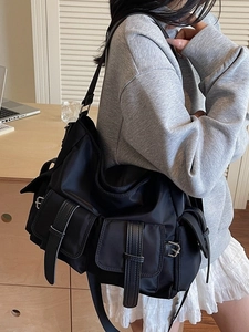 Large black functional nylon tote bag with front flap pockets and leather straps