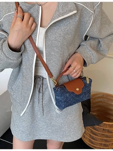 Polka dot denim crossbody bag with brown leather trim and metallic zipper closure