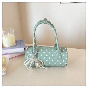 Détail du sac cylindrique vert menthe à pois avec charms perle et cœur argenté