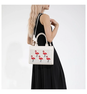 Détail du sac bandoulière blanc avec broderie de flamants rouges et texture tissée chic