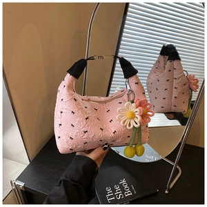 Detail der rosa Hobo-Tasche mit Schleifendruck, Gänseblümchen-Anhänger und Textur