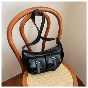 Detailed view of the black crescent underarm bag with square pockets and silver buckles