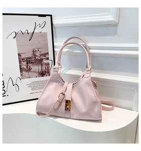 Détail du sac à main rose en cuir grainé avec fermoir doré et bandoulière réglable