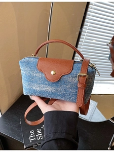 Vintage denim and brown leather mini crossbody bag with golden buckle on wooden table